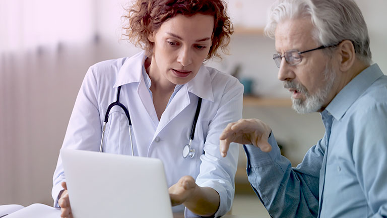 רופאה ומטופל מסתכלים על מסך מחשב